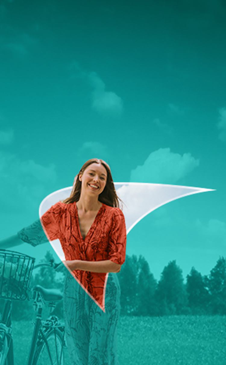 Picture of a young woman walking while holding on to a bike.